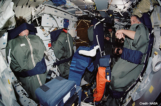 Image of STS-112 crewmembers sleeping in the middeck of the Space Shuttle Atlantis