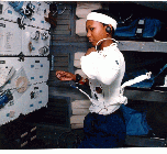 Image of a crew member working in the space shuttle in an AFS-2 suit.
