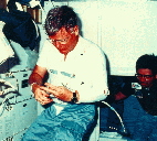 Image of a crew member working in the space shuttle in an AFS-2 suit.