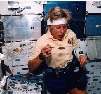 Image of a crew member working in the space shuttle in an AFS-2 suit.