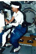 Image of a crew member working in the space shuttle in an AFS-2 suit.