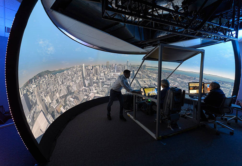 Researchers from the Aerospace Cognitive Engineering (ACE) Laboratory working with up a simulator