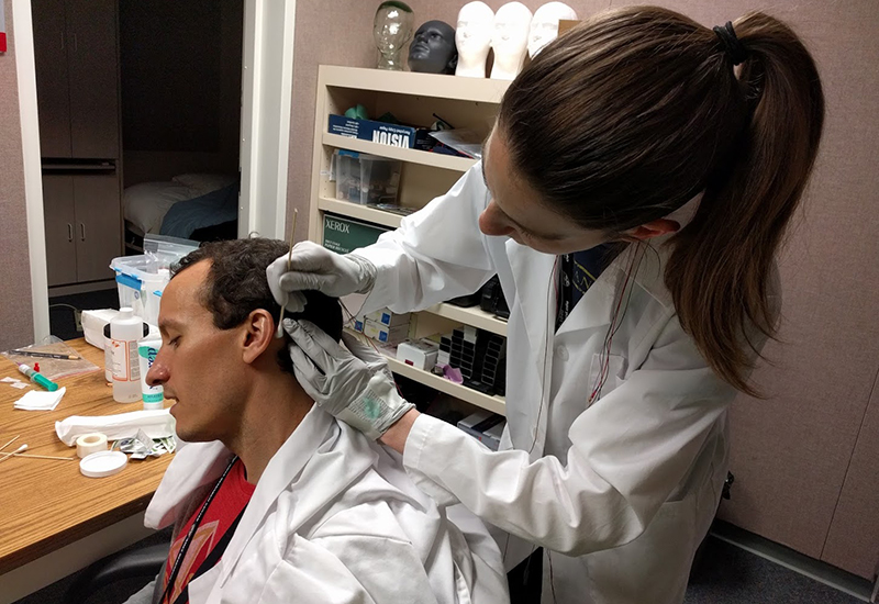 A Fatigue Countermeasures Laboratory researcher is prepping a subject for a fatigue research study