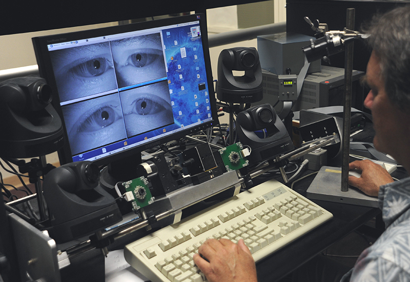 A NASA researcher from the Vision Sciences and Technology Group is monitoring research subjects in a Vision study